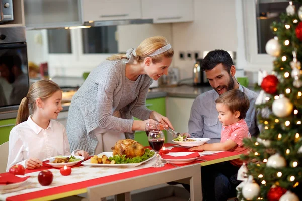 Mãe servindo peru para sua família no jantar de Natal — Fotografia de Stock