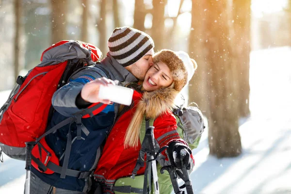 Jóvenes esquiadores besándose mientras hacen selfie —  Fotos de Stock