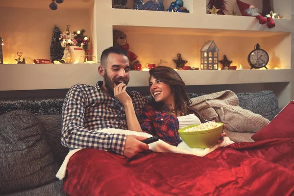 Kerst koppel ogende film en popcorn eten in bed — Stockfoto