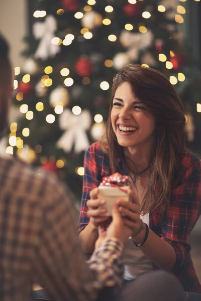Smiling girl takes Christmas gift from her boyfriend — Stock Photo, Image