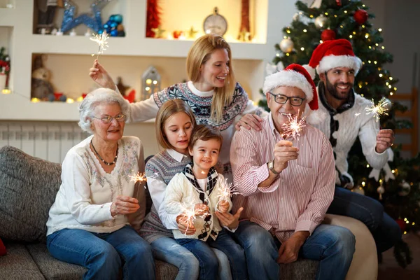 Abuelos con niños brillando con destellos de Navidad — Foto de Stock