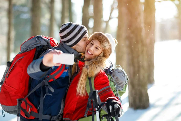 Mannelijke bergbeklimmer zijn vriendin zoenen terwijl het maken van de selfie — Stockfoto