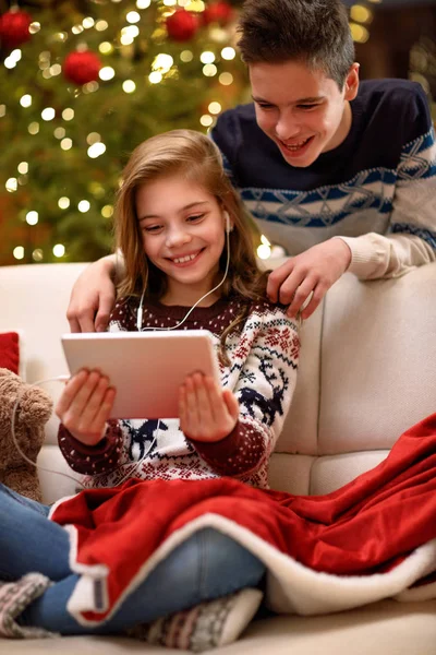 Brat i siostra cieszyć się w Wigilię Bożego Narodzenia, z muzyką z tabletu — Zdjęcie stockowe