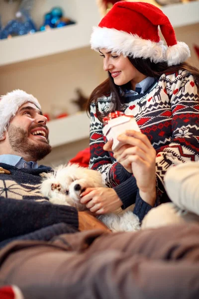 Navidad, vacaciones y concepto de la gente - pareja feliz en el sombrero de Santa — Foto de Stock