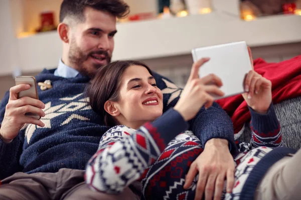 Kerst tijd-paar ontspannen thuis en met behulp van tabel — Stockfoto