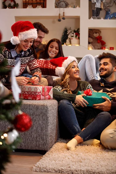 Cheerful friends exchanging gift boxes at Christmas eve — Stock Photo, Image