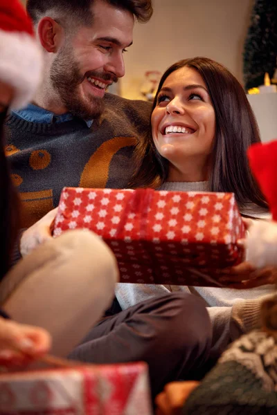 ロマンチックなカップルはクリスマスイブの日にギフト ボックスを交換 — ストック写真