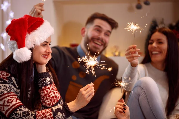 Friends with sparklers enjoying in party on Christmas day — Stock Photo, Image