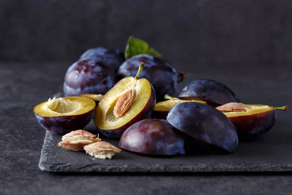 Freshly picked organic plums on dark table — Stock Photo, Image