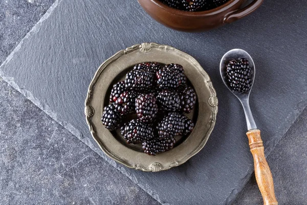 皿とスプーンの健康的なスナックのブラックベリー — ストック写真