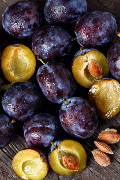 Top view on raw plums on wooden table background — Stock Photo, Image