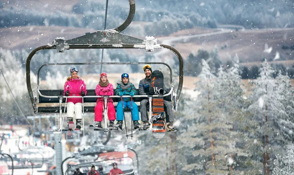 有孩子的父母在滑雪电梯攀登在滑雪地形 — 图库照片