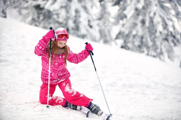 Girl on ski terrain practice to raise from snowy terrain — Stock Photo, Image