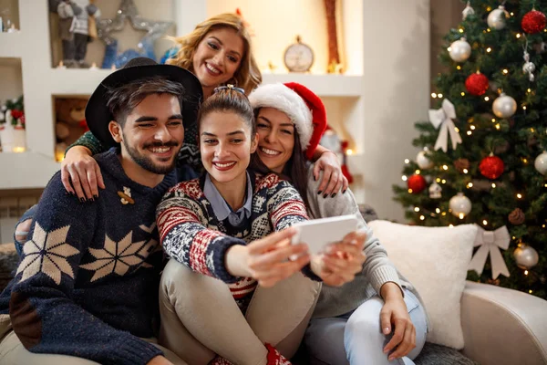 Ungdom i gruppe som tar juleselfie – stockfoto