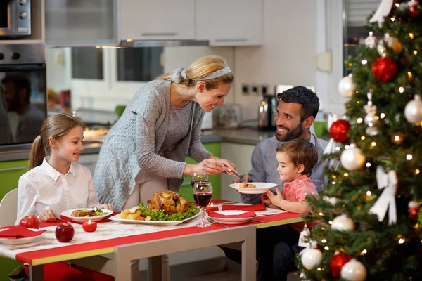 Family together at decorated table having festively dinner — Stock Photo, Image