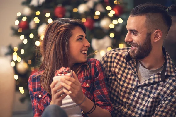 Female looking at male while holding Christmas present — Stock Photo, Image
