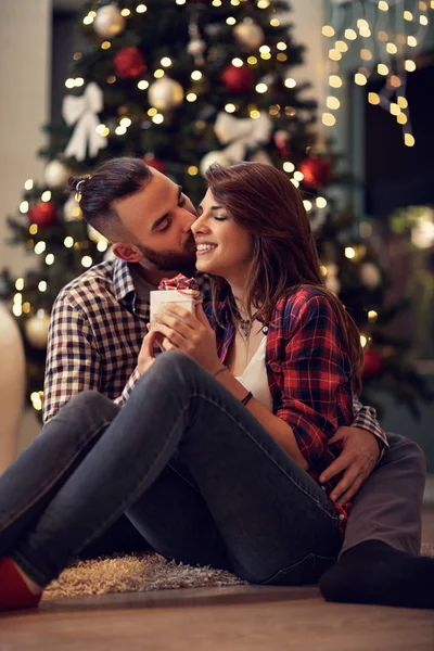 Marito abbraccio e bacia la moglie mentre le dà il regalo di Natale — Foto Stock