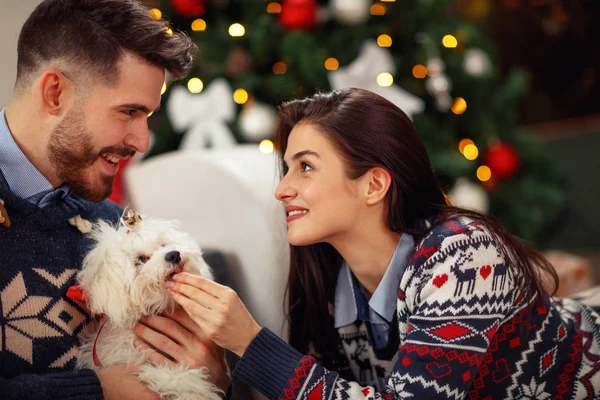 Γυναίκα με άντρα στο σπίτι με χαριτωμένο σκυλί γιορτάζει την παραμονή Χριστουγέννων — Φωτογραφία Αρχείου