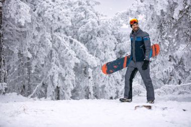 kar maskesi tutarak onun snowboard, aşırı spor ile gülümseyen adam 