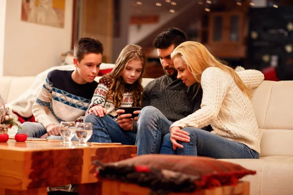 Família jogar jogo no telefone móvel no feriado de Natal — Fotografia de Stock