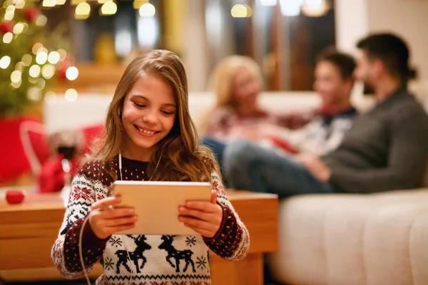 Niña con tablet y auriculares en casa — Foto de Stock