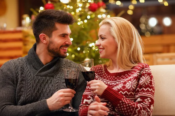 Par som firar jul grillas med glasögon rött vin — Stockfoto