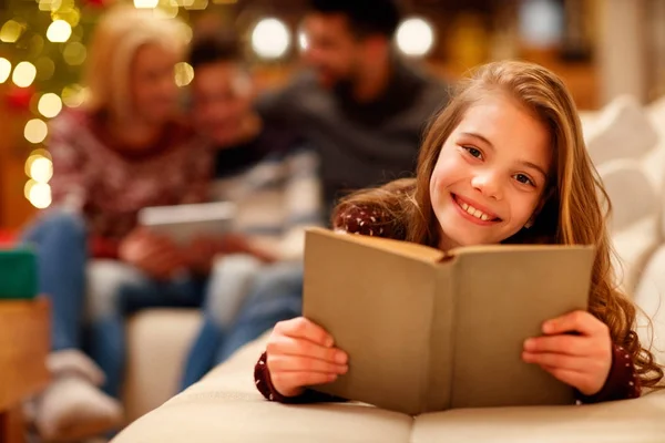 Liten flicka liggande och läsande barn bok i julklapp — Stockfoto