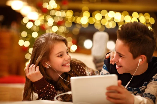 Дети вместе наслаждаются музыкой из планшета — стоковое фото