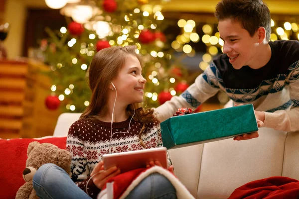 Hermano dando regalo de Navidad en caja a su hermana — Foto de Stock