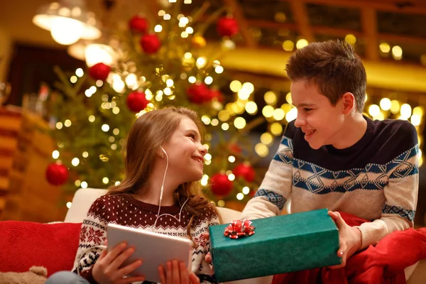 Irmão mais velho surpresa com presente sua irmãzinha no Natal — Fotografia de Stock