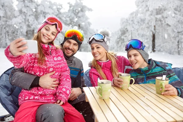 Chica con padres y hermano haciendo selfie en vacaciones de invierno —  Fotos de Stock