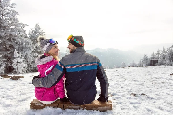 Pareja enamorada sentada en terreno de esquí —  Fotos de Stock
