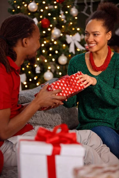 Afroamerikanisches Paar tauscht Geschenk zu Weihnachten aus — Stockfoto