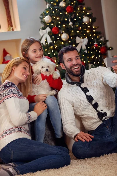 Рождество, праздники, технологии и люди концепт - семья делает селфи — стоковое фото