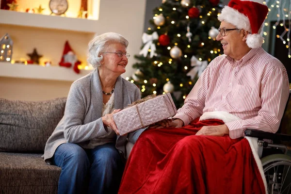 Pareja mayor en Navidad compartiendo regalo de Navidad — Foto de Stock