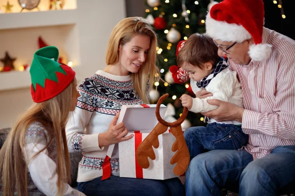 Сім'я проводить різдвяний час відкриваючи подарунок — стокове фото
