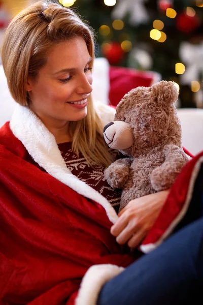 Γυναίκα αγκαλιάζει ένα χαριτωμένο αρκουδάκι και ξεκούραση στις διακοπές των Χριστουγέννων — Φωτογραφία Αρχείου