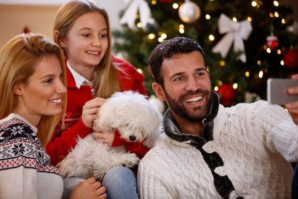 Pais com filha e filhote fazendo selfie de Natal — Fotografia de Stock