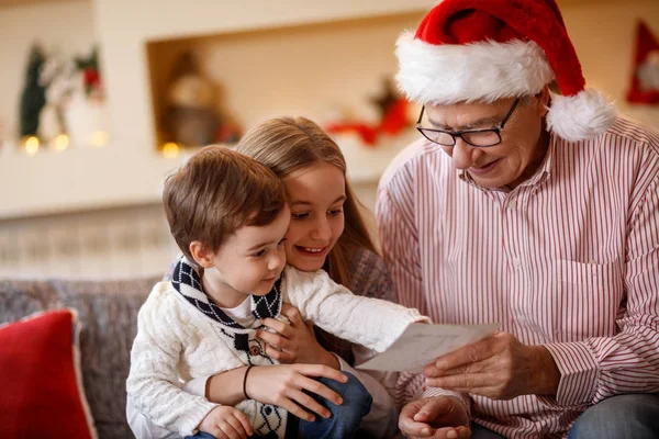 Abuelo con nietos mirando la foto — Foto de Stock