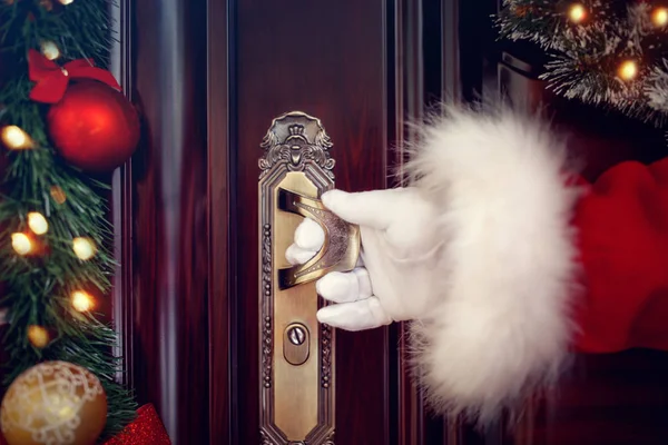 Santa Claus gehandschoende handen open de deur — Stockfoto