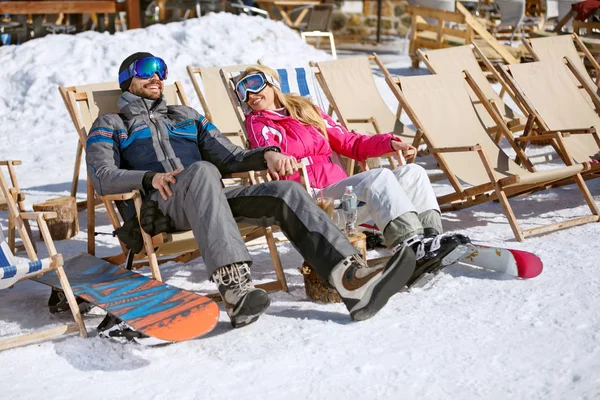 Esquiadores masculinos e femininos desfrutam em espreguiçadeiras — Fotografia de Stock