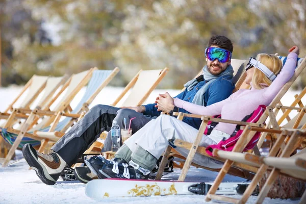 Par njuta av i en solstol på ski terräng — Stockfoto