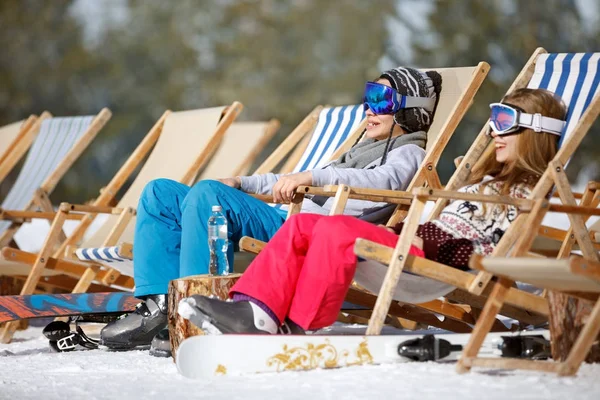 Brother and sister sitting in sun loungers — Stock Photo, Image