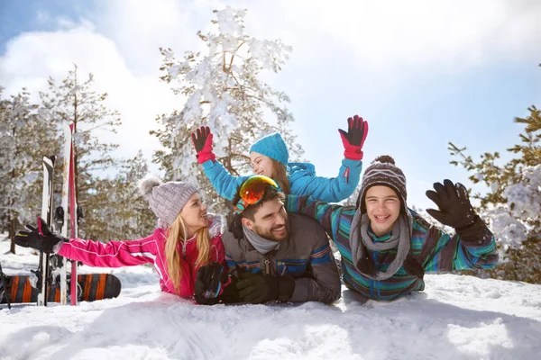 Счастливая семья веселится на снегу — стоковое фото