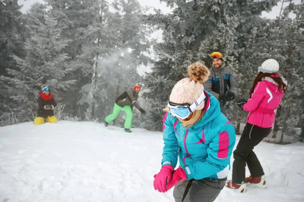 Freunde spielen bei Kälte mit Schneeball im Schnee — Stockfoto