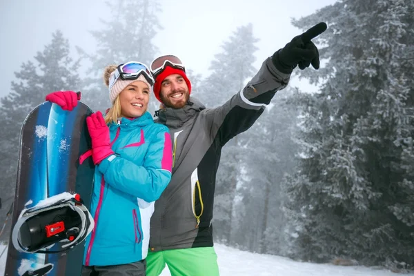 Coppia snowboarder godendo presso la stazione sciistica in montagna — Foto Stock