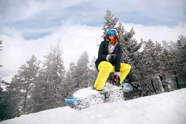 Niña snowboarder en salto en estación de esquí en la montaña —  Fotos de Stock