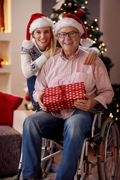 Retrato de hija y padre anciano en silla de ruedas en Navidad — Foto de Stock