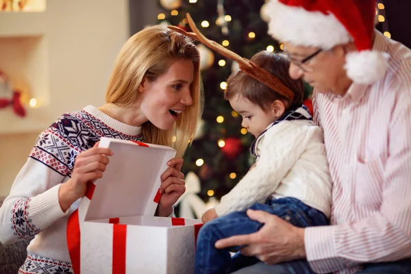 Поделиться подарком на Рождество улыбающаяся мать дарит подарок сыну — стоковое фото