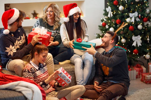Друзі сміються і діляться різдвяним подарунком — стокове фото